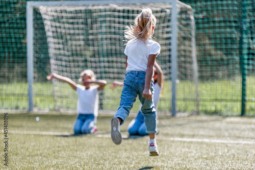 Girl soccer player runs on the field to her friends