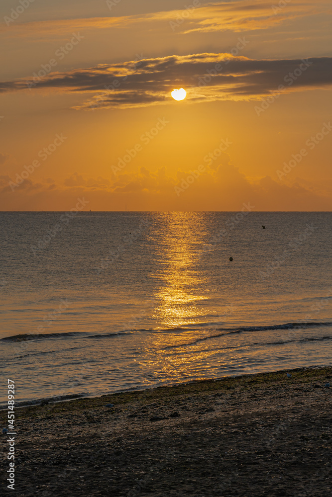 Langrune-Sur-Mer, France - 08 03 2021: Sunrise over the sea from the beach