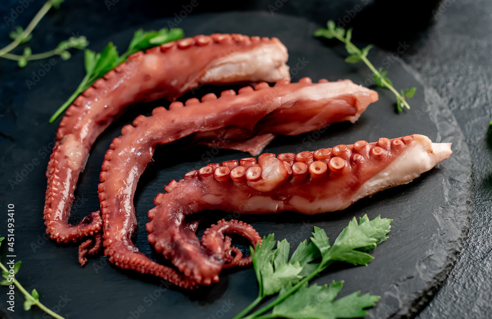 Boiled octopus tentacles on a stone background. Seafood. Boiled octopus tentacles on a stone background. Seafood.
