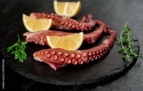  Boiled octopus tentacles on a stone background. Seafood.