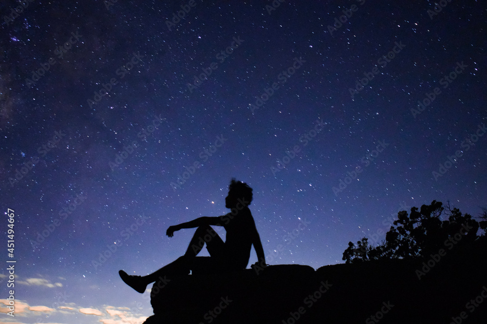 silhouette of a person staring at stars