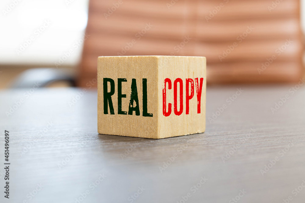 Wooden blocks form the words 'real copy', miniature wooden houses. Wooden blocks form the words 'real copy', miniature wooden houses.