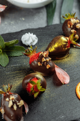 Fresh chocolate covered strawberries on a gray decorative background. Concept for advertising the summer seasonal menu