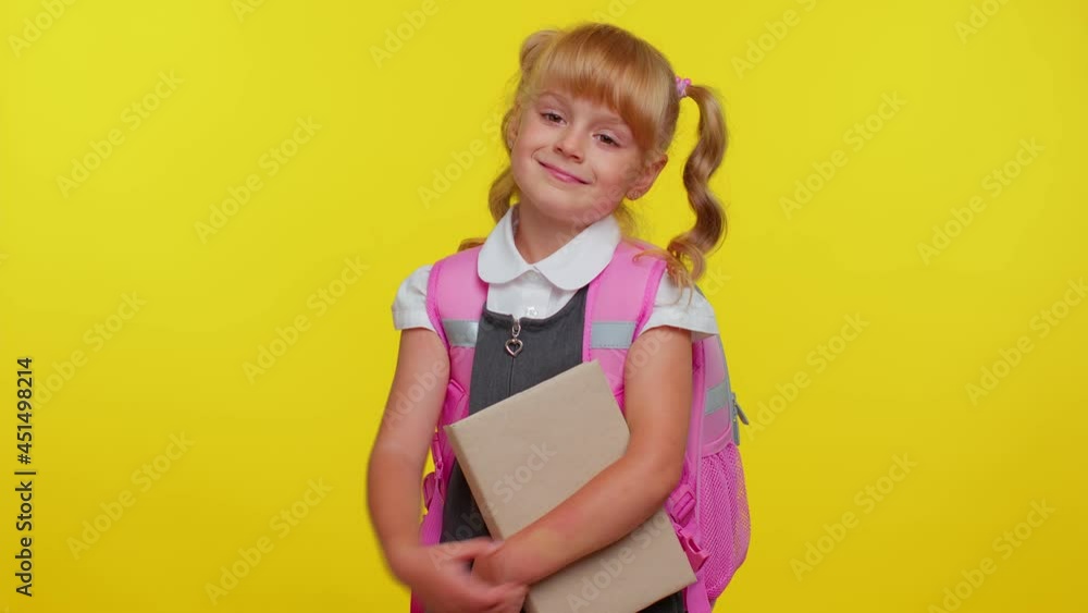 Little blonde child kid girl in school uniform showing biceps and looking confident, feeling power strength for study, energy to gain success win. Yellow studio background. Back to school. Childhood Little blonde child kid girl in school uniform showing biceps and looking confident, feeling power strength for study, energy to gain success win. Yellow studio background. Back to school. Childhood