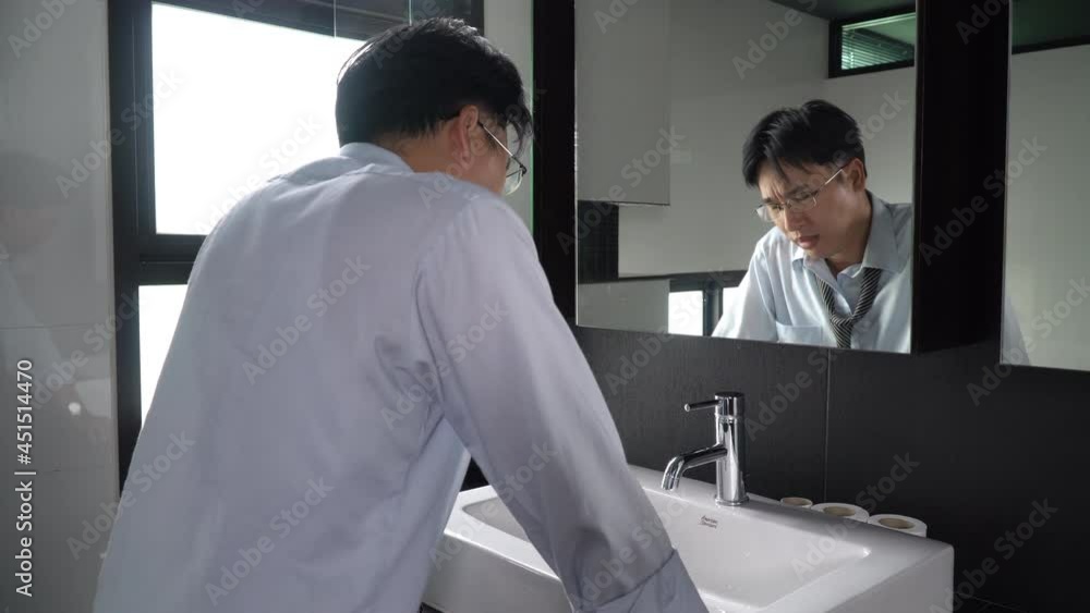 Unemployed Asian man standing in front of mirror screaming and blame himself mistake. Stressed businessman entrepreneur unsuccessful in business. Mental health and economic financial problem concept. Unemployed Asian man standing in front of mirror screaming and blame himself mistake. Stressed businessman entrepreneur unsuccessful in business. Mental health and economic financial problem concept.