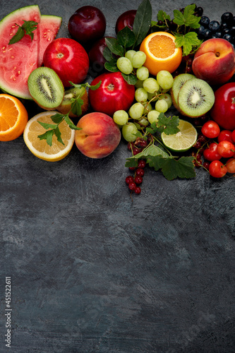 Assorted fresh fruits on dark background.