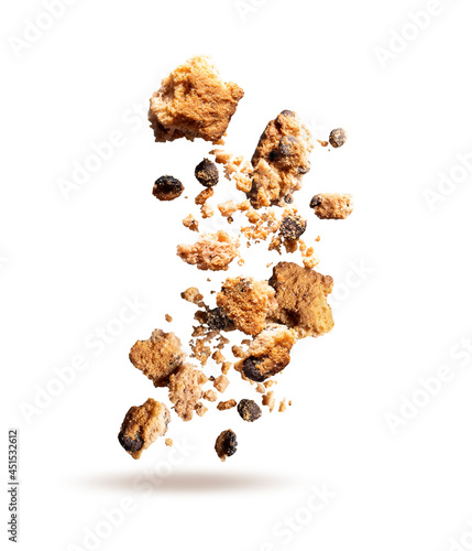 Fly crumbs of oatmeal cookies. Cookie crumbs with chocolate pieces isolated on white background. Crumbs of oatmeal cookies closeup.