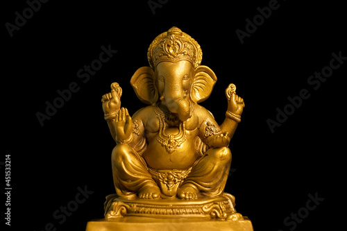 Golden lord ganesha sclupture over dark background. celebrate lord ganesha festival. photo