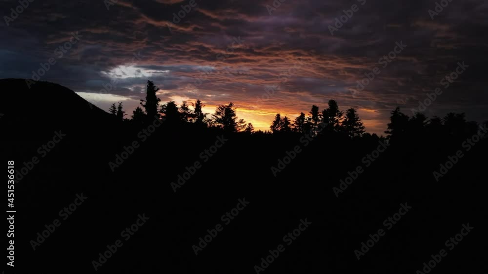 Inspiring and astonishing natural wonder aerial drone shot of silhouette forest during fantastic colorful sunset with dark mountains at cloudy day. Mesmerizing and seeing nature, environment concept Inspiring and astonishing natural wonder aerial drone shot of silhouette forest during fantastic colorful sunset with dark mountains at cloudy day. Mesmerizing and seeing nature, environment concept