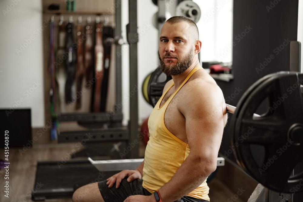 Strong bodybuilder with muscular chest and shoulders in gym Strong bodybuilder with muscular chest and shoulders in gym