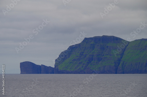 Beautiful rock cliff coast line of Faroe Islands with breathtaking landscape nature scenery, popular cruise travel destination in Atlantic Ocean near Polar Circle for expedition tours photo