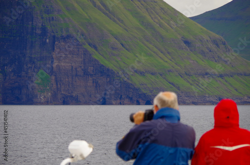 Expedition cruising on luxury cruiseship cruise ship liner to Nordic adventure Polar Circle Faroe Islands with breathtaking nature landscape scenery cliffs coast line photo