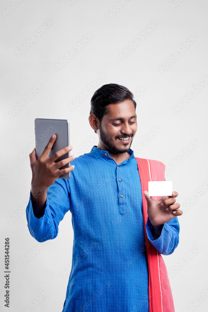 Young indian farmer using tablet and giving expression on white background. Young indian farmer using tablet and giving expression on white background.