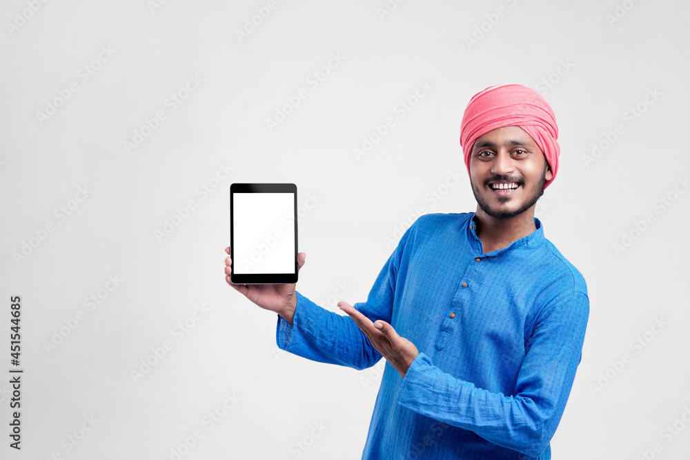 Young indian farmer showing tablet and giving expression on white background. Young indian farmer showing tablet and giving expression on white background.