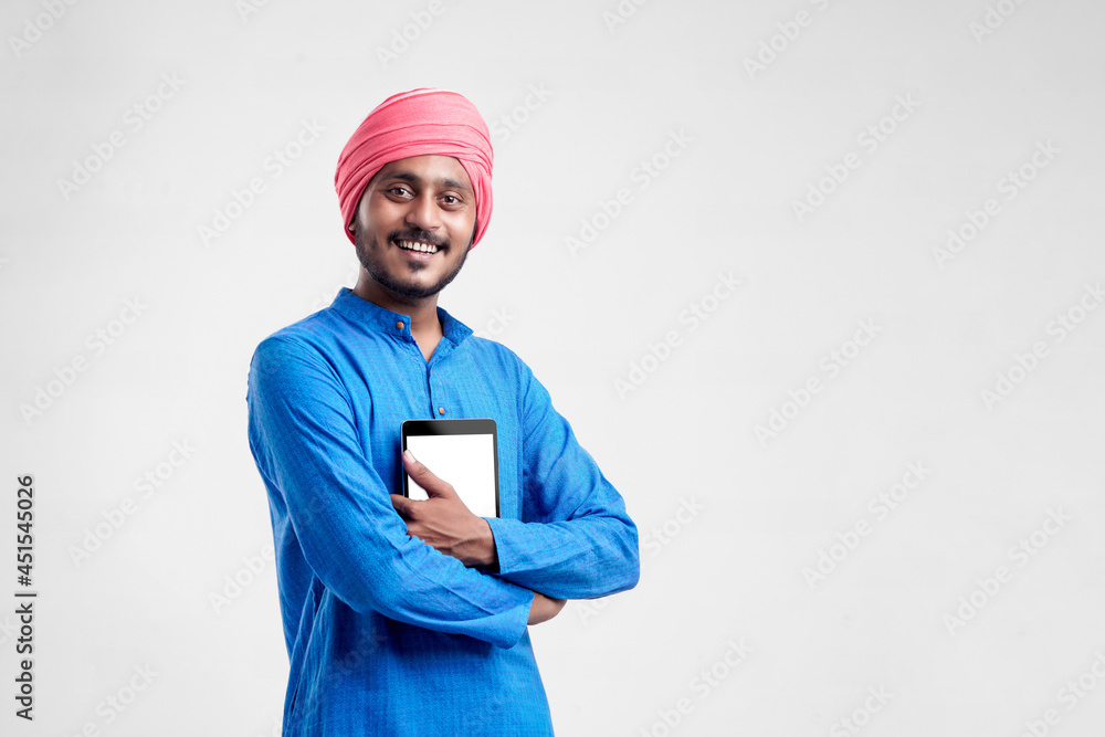 Young indian farmer using tablet and giving expression on white background. Young indian farmer using tablet and giving expression on white background.