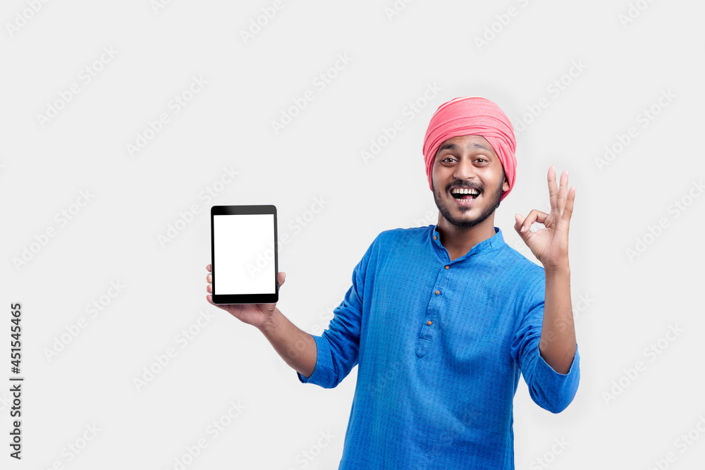Young indian man in traditional wear and showing tablet over white background. Young indian man in traditional wear and showing tablet over white background.