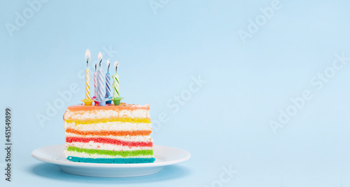 Birthday or holiday cake with burning candles on a blue
