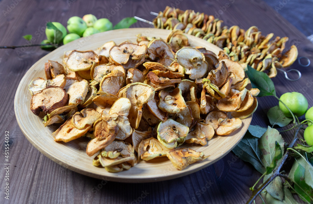 Dry apple slices on plate on wooden background Dry apple slices on plate on wooden background