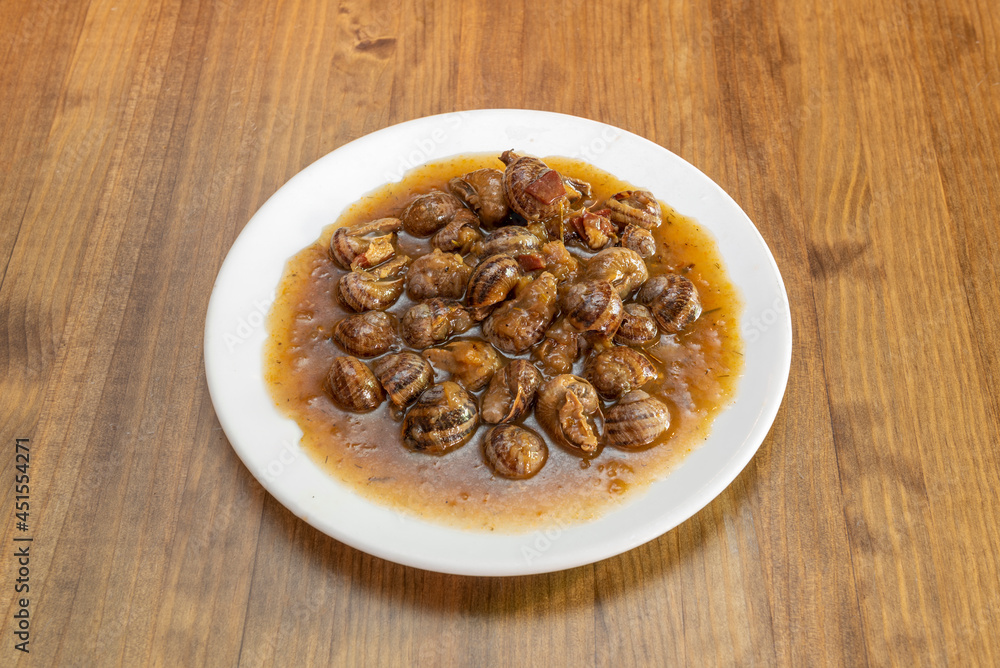 Typical Spanish recipe of snails stewed in sauce presented in a Madrid tapas restaurant