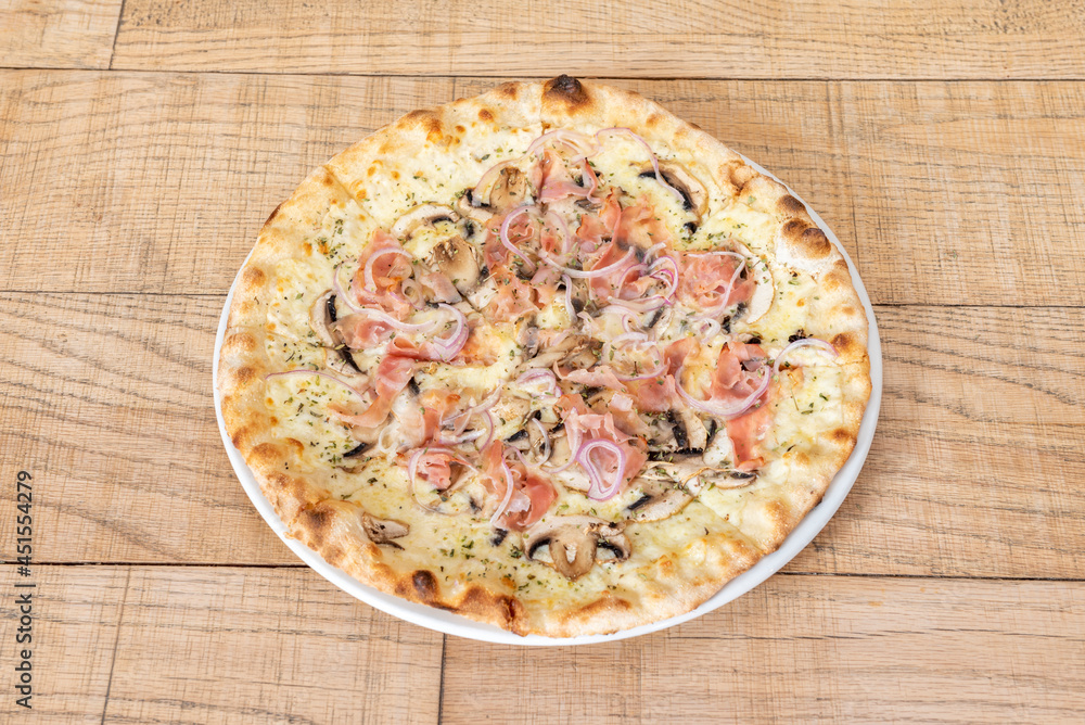 Great family pizza sliced and cooked with carbonara recipe with red onion, ham, mushrooms and melted cheese Great family pizza sliced and cooked with carbonara recipe with red onion, ham, mushrooms and melted cheese