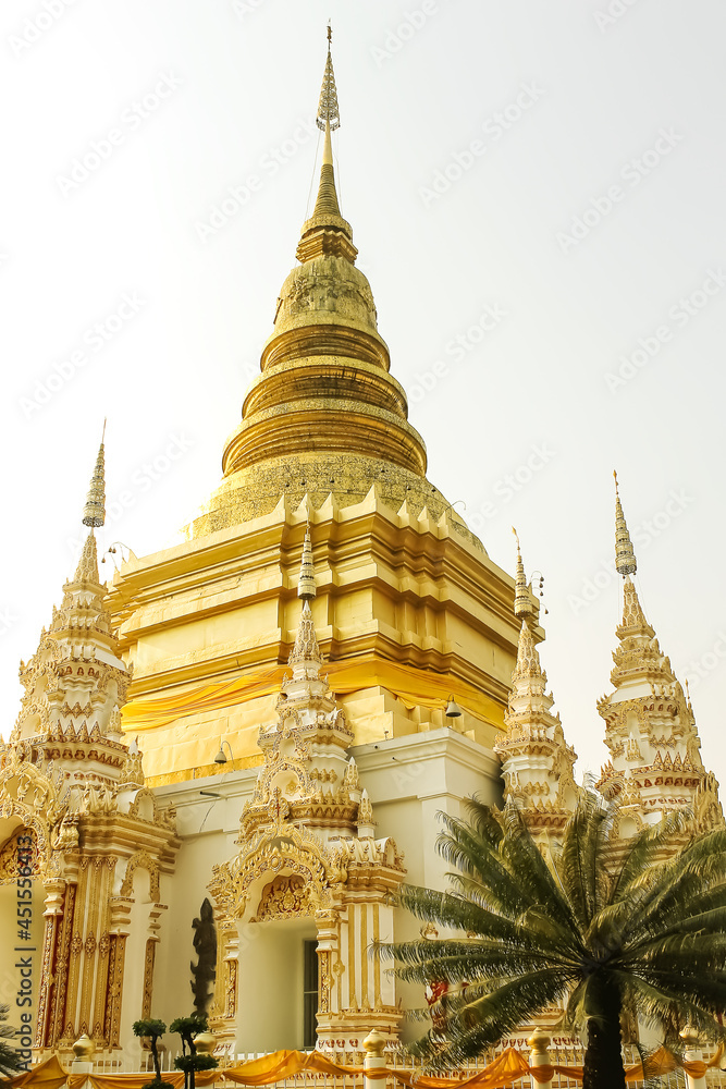 Fototapeta premium Gold pagodaon on white sky background at at Wat Phra Phutthabat Tak Pha in Lamphun , Thailand