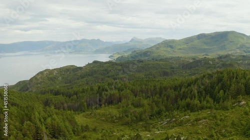 Lush Green Landscape With Calm Waters In Maloy, Norway On A Misty Day. wide aerial photo