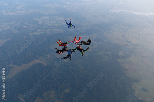 Skydiving.  A team of skydivers is in the sky.