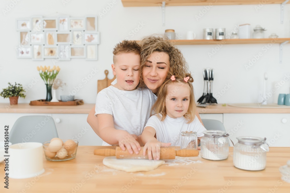happy family in the kitchen. mother and children preparing the dough, bake cookies happy family in the kitchen. mother and children preparing the dough, bake cookies