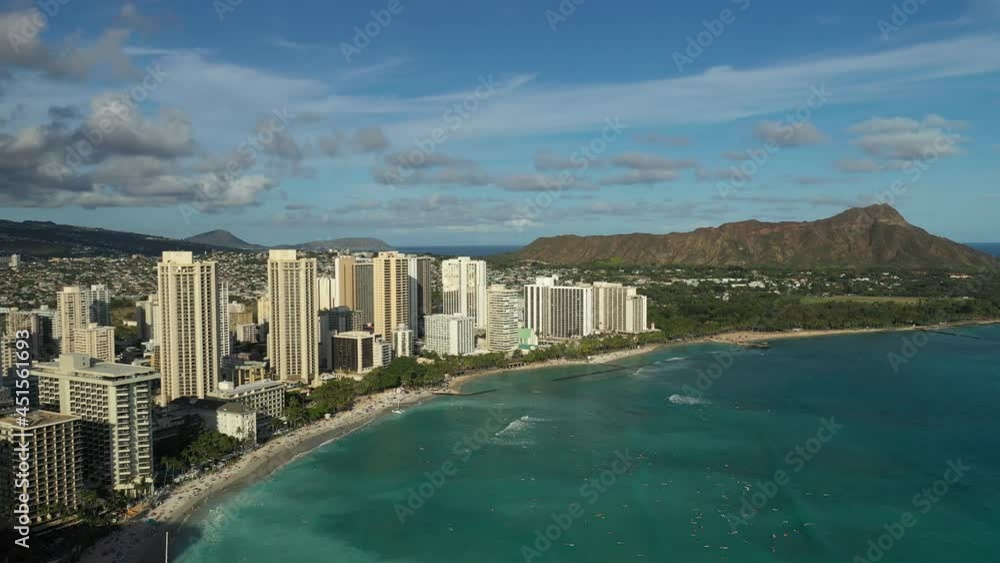 Aerial drone view flying above Waikiki Beach on the island of Oahu, Hawaii, USA. Boats visible on water, hotels and people on the beach. Diamond Head volcano in the background. Late afternoon light. Aerial drone view flying above Waikiki Beach on the island of Oahu, Hawaii, USA. Boats visible on water, hotels and people on the beach. Diamond Head volcano in the background. Late afternoon light.