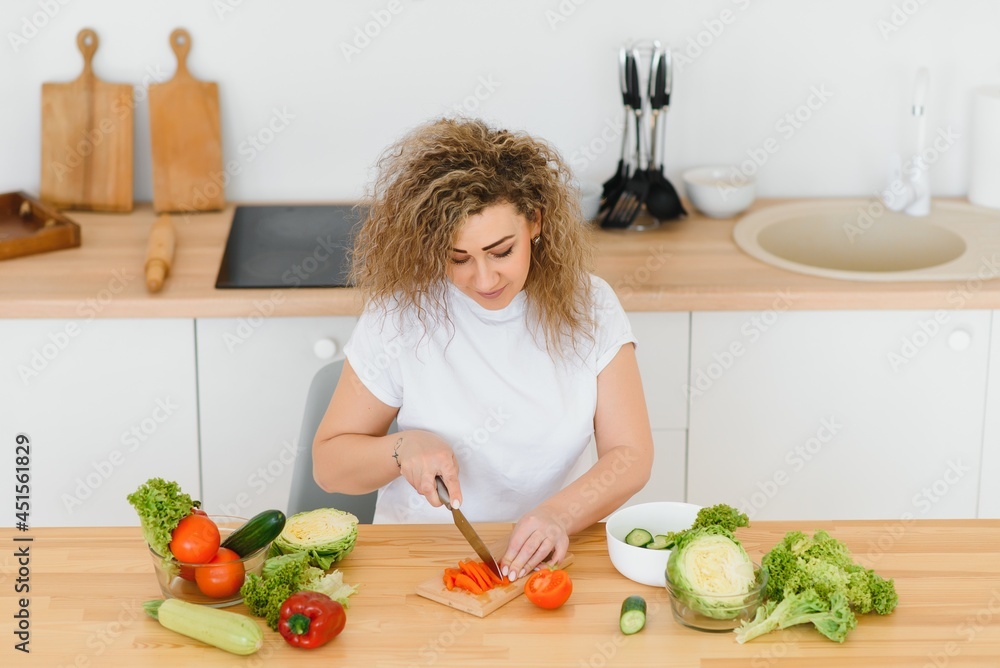 Woman making salad in kitchen. Healthy eating lifestyle concept with beautiful young woman cooking in her kitchen. Woman making salad in kitchen. Healthy eating lifestyle concept with beautiful young woman cooking in her kitchen.