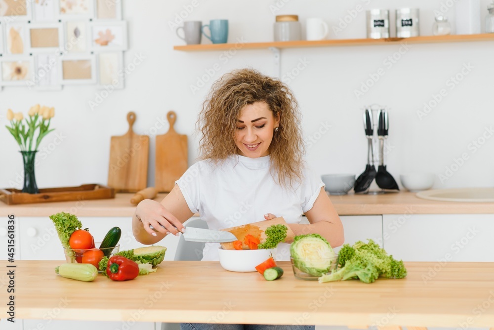 Woman making salad in kitchen. Healthy eating lifestyle concept with beautiful young woman cooking in her kitchen. Woman making salad in kitchen. Healthy eating lifestyle concept with beautiful young woman cooking in her kitchen.