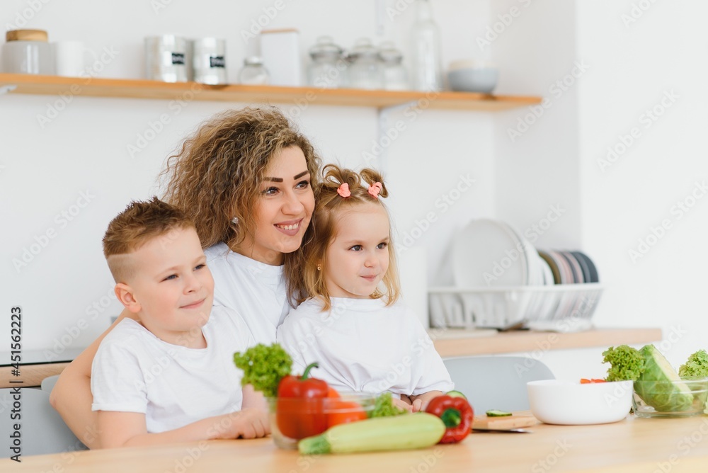 mother with children preparing vegetable salad at home mother with children preparing vegetable salad at home