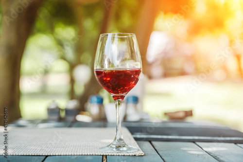 A glass of red wine on the table of a street cafe a sunny summer day. Summer, lifestyle, relaxation, and enjoyment concept.