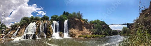 muradiye waterfall, van province turkey. open air view of trees and exuberant waterfall.