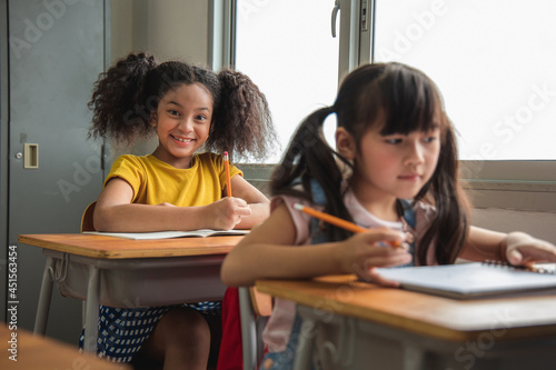 Portrait of Asian elementary school kids studying in a class. The girl Positive, Happy, smiles and look at the camera at the classroom. Back to school concept