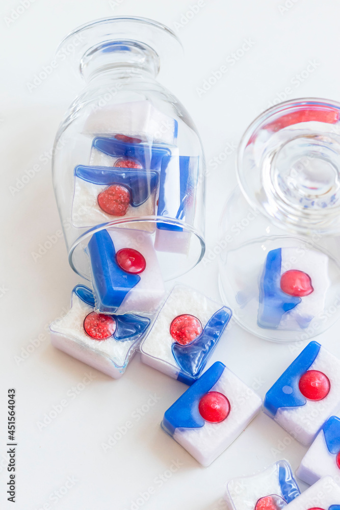 Dishwasher tablets, on white background with utensils Dishwasher tablets, on white background with utensils