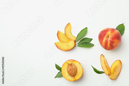 Ripe peach fruits with leaves on white background