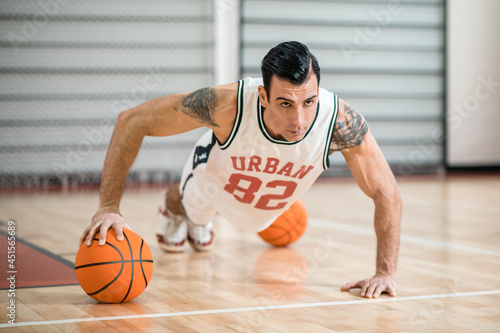 Young man with tatoo having a workout in gym