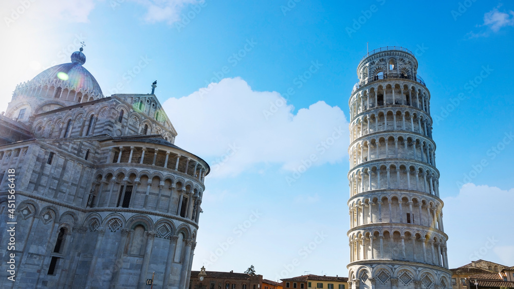 The Leaning Tower of Pisa on a clear day with white cloudy and sunlight in the sky background-Travel landmark concept