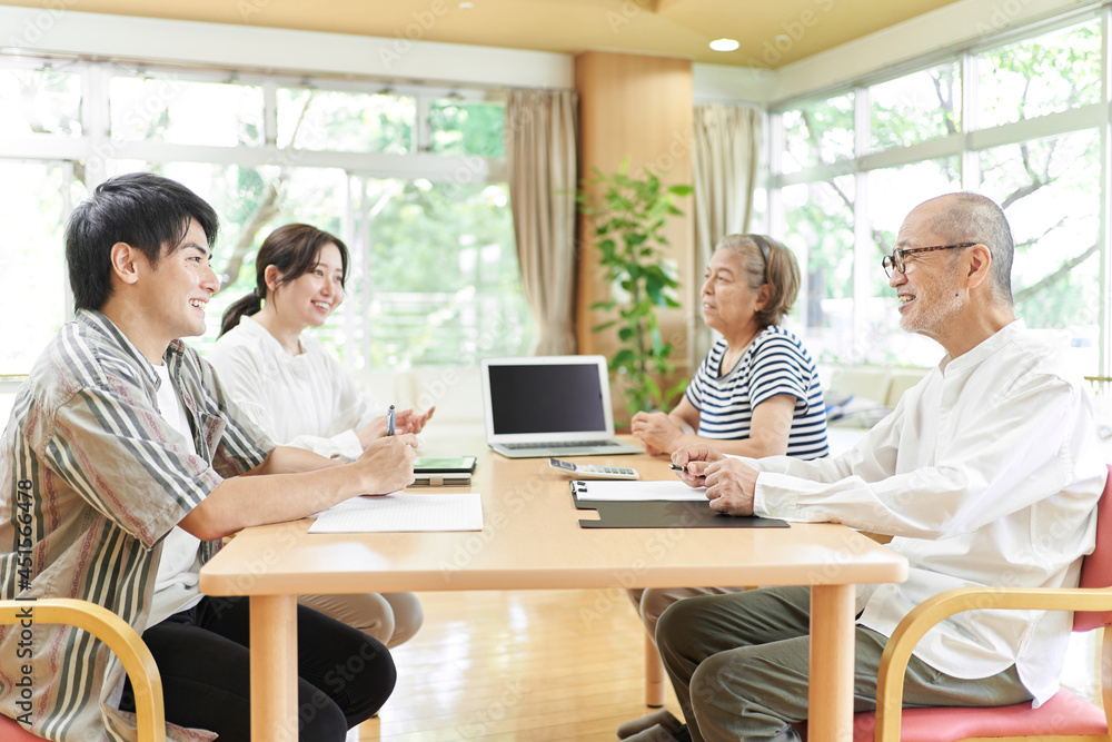 笑顔で会話する若夫婦と老夫婦