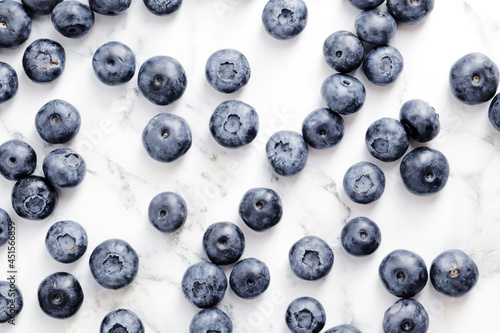 composition of ripe blueberries on a textured marble background