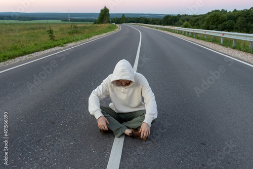 a man sits in the middle of the road.