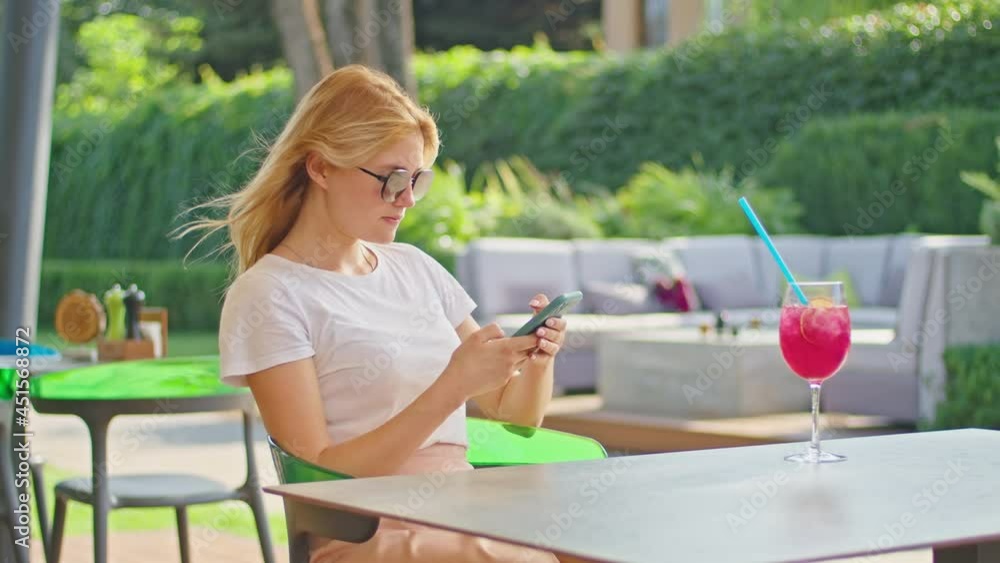 young woman enjoys talking on the phone, texting with someone, in a wonderful place, sitting in a white t-shirt young woman enjoys talking on the phone, texting with someone, in a wonderful place, sitting in a white t-shirt