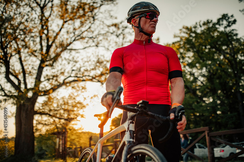Senior man cycling through forest
