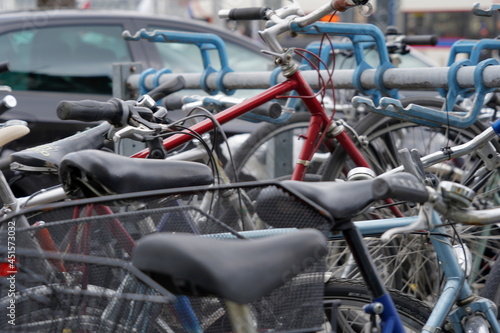 Bicycles parked on a busy street with cars. Background picture to mobility or alternative transport in cities.  © Lucia