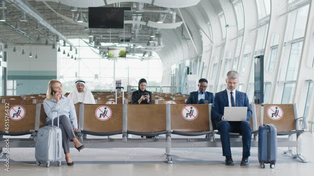 Passengers sitting at the social distance at airport terminal station. Contact less concept prevent the spread of COVID-19 outbreak Passengers sitting at the social distance at airport terminal station. Contact less concept prevent the spread of COVID-19 outbreak