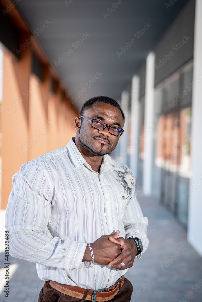Happy handsome man standing by the modern office and looking at the camera. Pleasant mood because of good news. Successful start up and positive emotions concept Happy handsome man standing by the modern office and looking at the camera. Pleasant mood because of good news. Successful start up and positive emotions concept