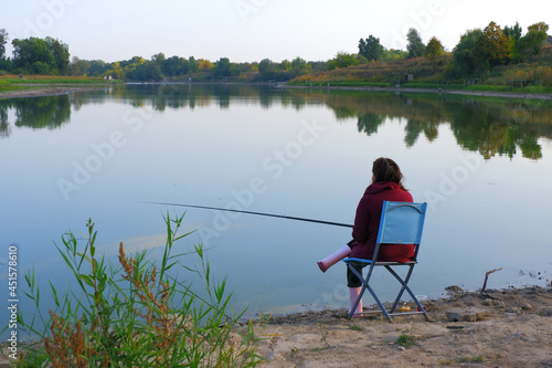 The fisherwoman is expecting a bite. Fishing. The Woman is fishing. Fisherwoman on the bank of the river. 