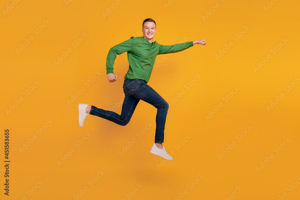 Portrait of superhero funky guy jump run save world on yellow background