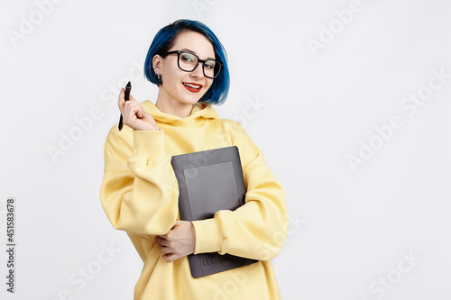A female designer in yellow hoody holding a graphic tablet. photo